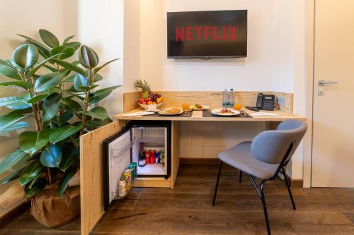 an office with a desk with a tv and a chair at Riserva Bianca Limone Hotel & SPA in Limone Piemonte
