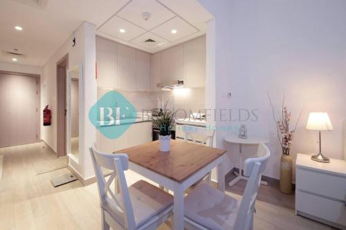 a dining room with a wooden table and chairs at Bloomfields Stu Canal View Waters Edge Yas Island in Abu Dhabi