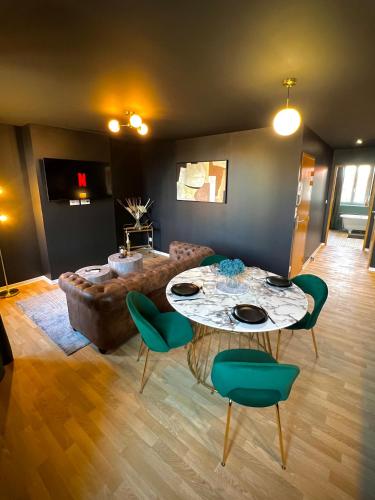 a living room with a table and a couch at Gatsby Room - Élégance et Intimité des Années 20 ! in Villeneuve-sur-Lot