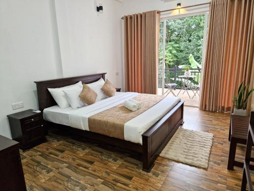 a bedroom with a large bed and a large window at Villa Sole in Kandy