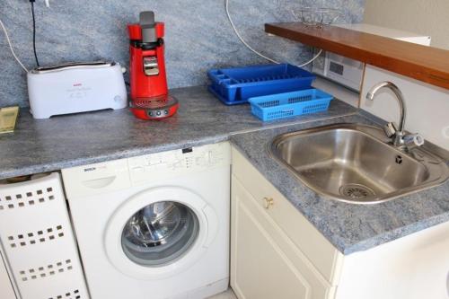 - un comptoir de cuisine avec évier et lave-linge dans l'établissement Appartement 2 pièces cabine - GRUISSAN GN400-013, à Gruissan