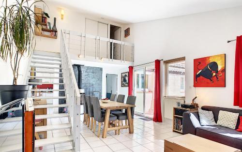 a living room with a staircase and a table and chairs at Chambre privée chez l'habitant - La Chambre Framboise in Colomiers