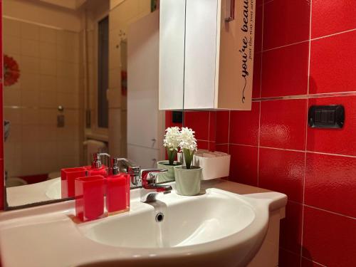 a bathroom with a sink and a red wall at Casa dolce casa - Metro in Sesto San Giovanni