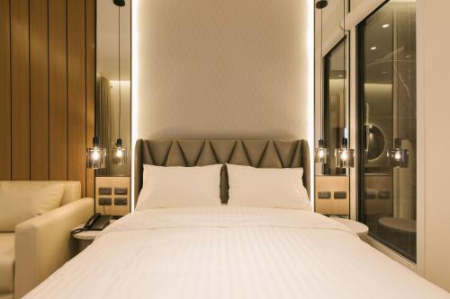 a bedroom with a large white bed and a window at Zeen Sky Resort in Ban Noi