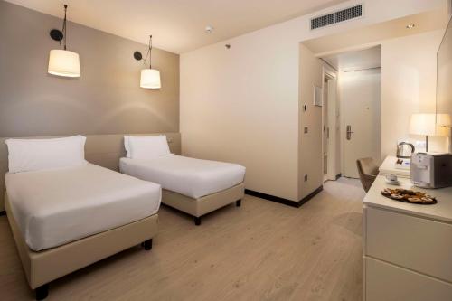 a hotel room with two beds and a kitchen at Best Western Plus Tower Hotel Bologna in Bologna