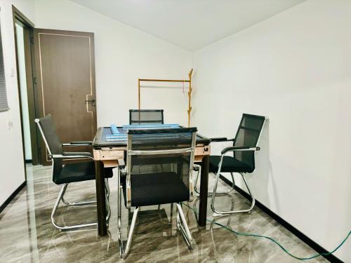 a room with a table with chairs and a laptop on it at Shiguanghui in Sanya