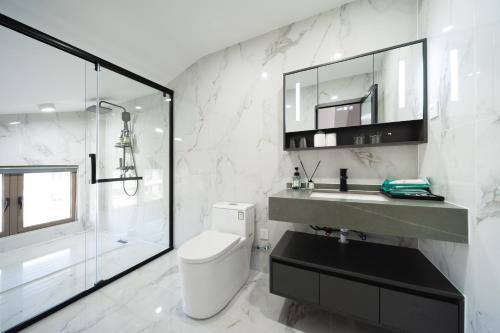 a bathroom with a toilet and a sink and a shower at Shiguanghui in Sanya