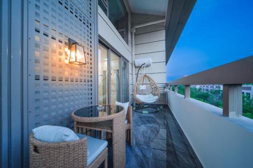 a balcony with wicker chairs and a table at Shiguanghui in Sanya