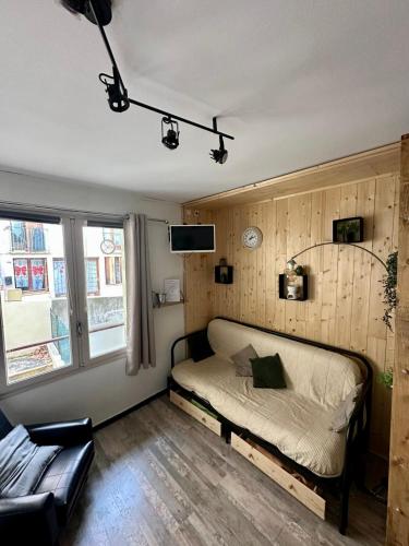 une chambre avec un lit et un canapé dans l'établissement Studio confort Amélie les bains à 2 pas des thermes, à Amélie-les-Bains-Palalda