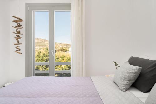 una camera da letto bianca con un letto e una finestra di Anamnesia Collection Villa Aronia Kastraki Beach a Naxos Chora