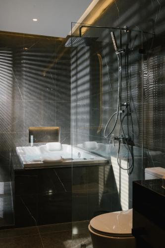 a bathroom with a tub and a toilet and a shower at Zeen Sky Resort in Ban Noi