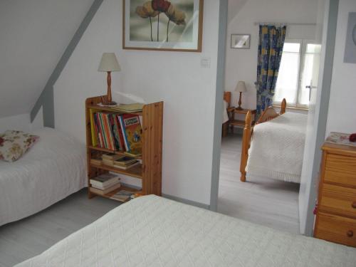 - une chambre avec un lit et une étagère avec des livres dans l'établissement Gîte du Clos Bouillon, à Saint-Loup-Hors
