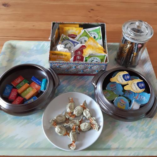 une table avec deux contenants de collations et une assiette de nourriture dans l'établissement Gîte du Clos Bouillon, à Saint-Loup-Hors