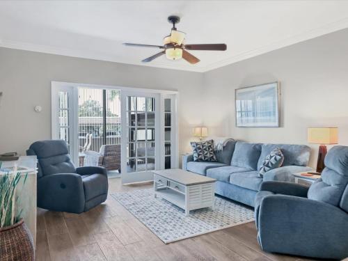 a living room with blue couches and a ceiling fan at Catch of the Day at Harbor Towers on Siesta Key in Siesta Key