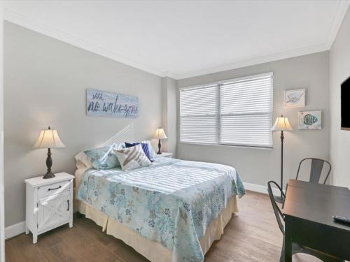 a bedroom with a bed and a desk and a window at Catch of the Day at Harbor Towers on Siesta Key in Siesta Key