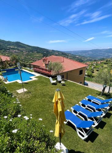 a group of lounge chairs and a swimming pool at Quinta do Sonho in Resende