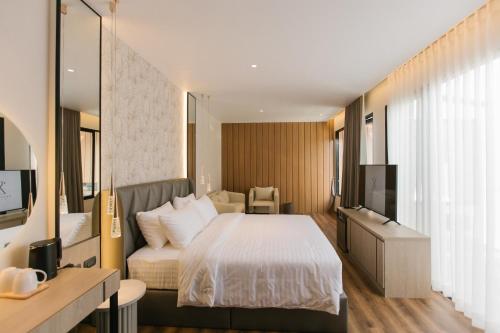 a hotel room with a bed and a television at Zeen Sky Resort in Ban Noi