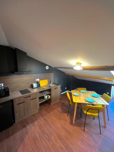 une cuisine avec une table et des chaises dans une pièce dans l'établissement Garçonnière - Refuge parfait pour Amis et Jeux !, à Villeneuve-sur-Lot