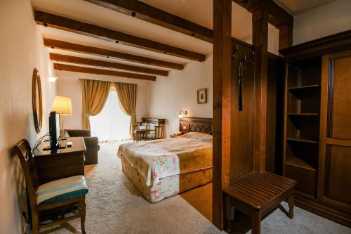 a bedroom with a bed and a chair and a window at Pensiunea Casa Nostalgia in Bran