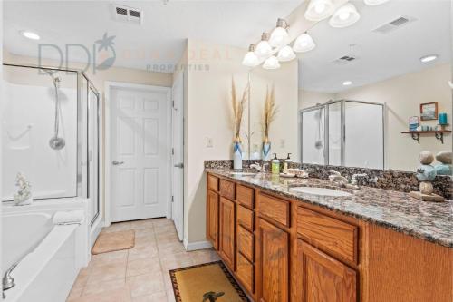 a bathroom with a double sink and a tub at Legacy Tower Two 1202 Deluxe in Gulfport