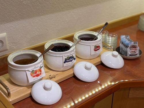 three buckets of coffee sitting on a wooden tray at Pension Isabella in Bad Kleinkirchheim