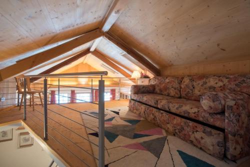 a living room with a couch in the attic at Residence Salvan in Corvara in Badia