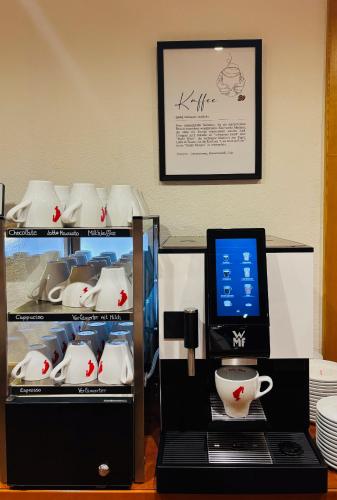 a desk with a laptop and a display with a tea set at Pension Isabella in Bad Kleinkirchheim