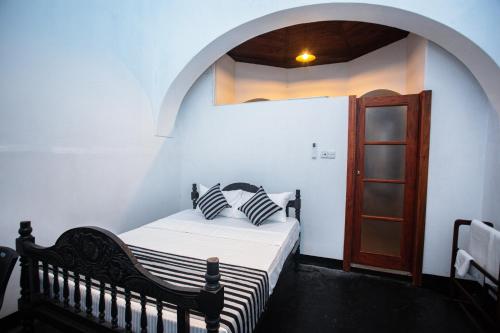 a bedroom with a bed and a wooden door at Villa 1908 in Dodanduwa
