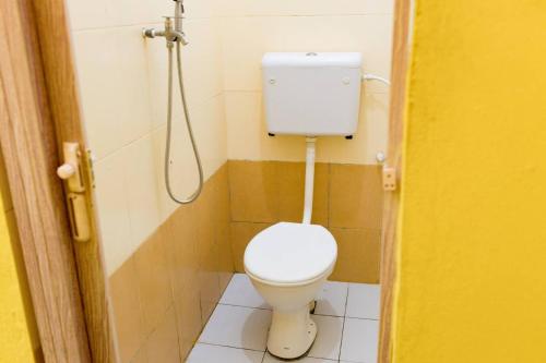 a small bathroom with a toilet and a shower at Hotel & Homestay Four Friends Tanah Merah, Kelantan in Tanah Merah