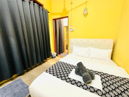 a bedroom with a bed with a pair of shoes on it at Hotel & Homestay Four Friends Tanah Merah, Kelantan in Tanah Merah