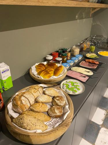 a table topped with lots of different types of bread at Arrábida Guest House in Setúbal