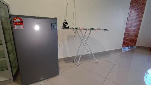 a table next to a refrigerator in a room at MUSANG ONG HOTEL in Cameron Highlands