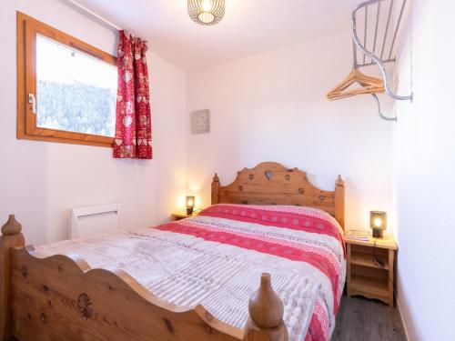 une chambre avec un lit en bois et une fenêtre dans l'établissement Confort et Wifi gratuit : Appartement 3 pièces pour 4-6 personnes, proche pistes et remontées mécaniques - FR-1-265-307, à Modane