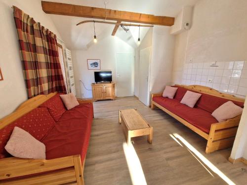 un salon avec un canapé rouge et une télévision dans l'établissement Grand appartement 10/12 pers, 5 pièces, proche pistes et centre - FR-1-265-327, à Modane