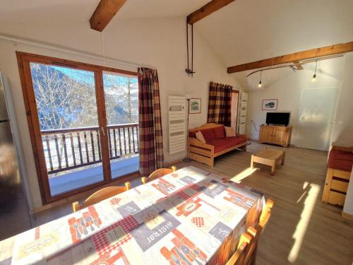 un salon avec une table et une grande fenêtre dans l'établissement Grand appartement 10/12 pers, 5 pièces, proche pistes et centre - FR-1-265-327, à Modane