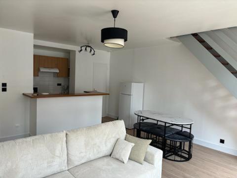 un salon avec un canapé blanc et une table dans l'établissement Les 4 saisons, à Le Touquet-Paris-Plage