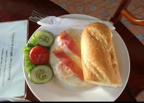 a plate of food with a sandwich and vegetables at Luangprabang Villa Suan Keo Two in Luang Prabang