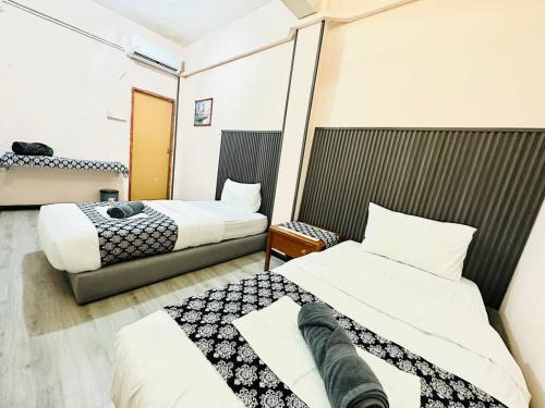 two beds in a hotel room with two beds at Hotel & Homestay Four Friends Tanah Merah, Kelantan in Tanah Merah