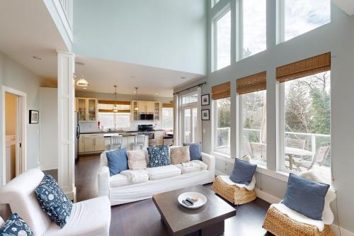 a living room with a white couch and blue pillows at Alder Beach House in Oceanside