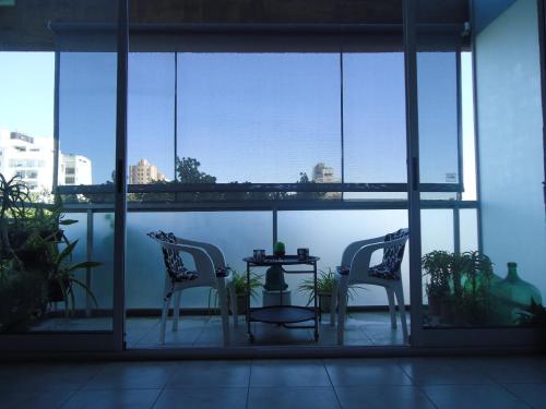 two chairs and a table in a room with windows at Departamento Calle 46 in La Plata