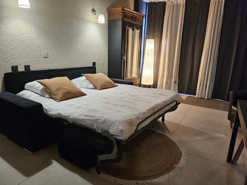 een slaapkamer met een groot bed met twee kussens erop bij le salon in Sablons