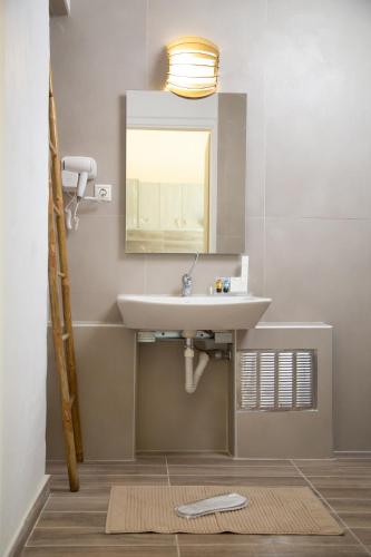 a bathroom with a sink and a mirror at Poseidon Apartments and Villas by the Sea in Sounio