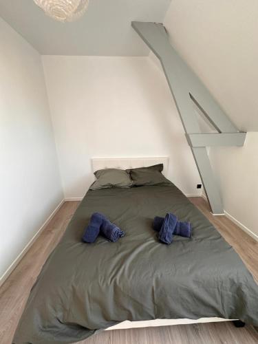 - un lit avec 2 oreillers bleus dans l'établissement Les 4 saisons, à Le Touquet-Paris-Plage