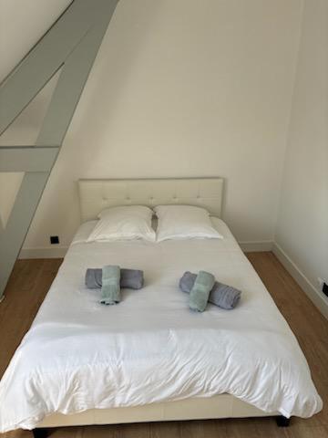 - un lit blanc avec 3 oreillers dans l'établissement Les 4 saisons, à Le Touquet-Paris-Plage