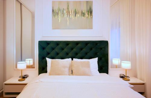 ein Schlafzimmer mit einem großen Bett mit grünem Kopfteil in der Unterkunft NEO Doi - central - City of Mara in Timişoara
