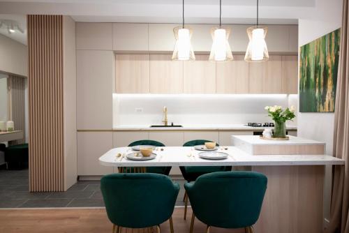 eine Küche mit einem weißen Tisch und grünen Stühlen in der Unterkunft NEO Doi - central - City of Mara in Timişoara