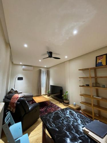 a living room with a couch and a ceiling fan at Elyu Guesthouse in Bauang