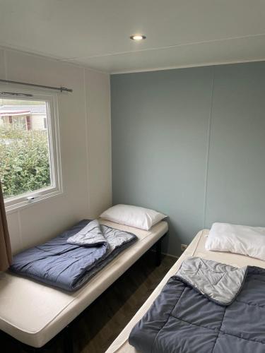 deux lits dans une chambre avec une fenêtre dans l'établissement mobil-home de 4 à 6 personnes, à Onzain