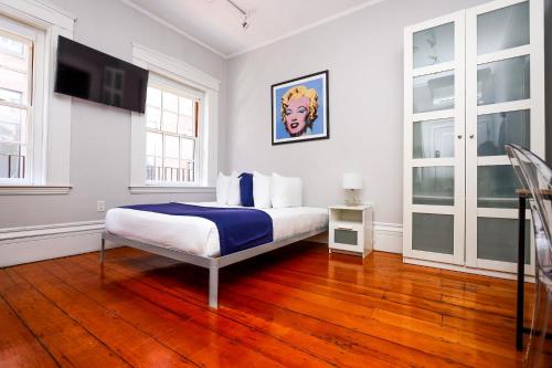 Un dormitorio blanco con una cama y un televisor. en Convenient Beacon Hill Rental by MGH & TD Garden #5, en Boston