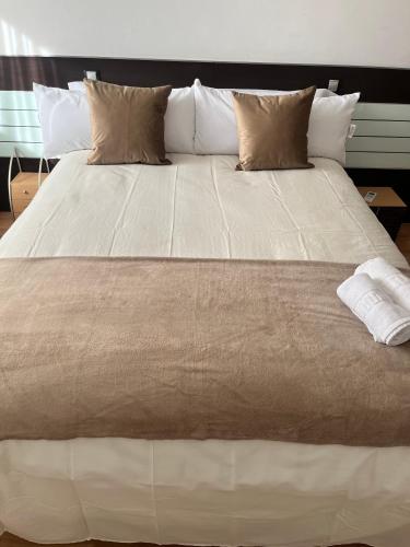 a large white bed with pillows on top of it at Apartamento en Zaragoza-3 in Zaragoza
